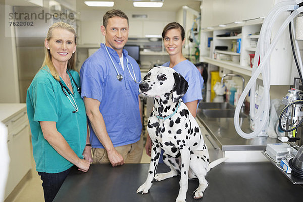Tierärzte lächeln mit Hund in der Tierarztpraxis