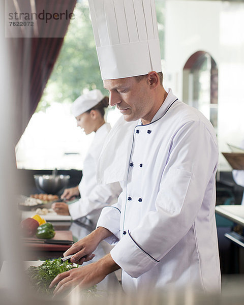 Chefkoch beim Schneiden von Gemüse in der Restaurantküche