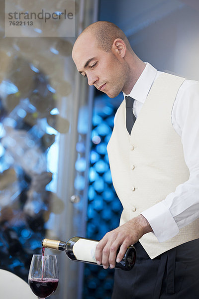 Kellner gießt ein Glas Wein in das Restaurant.