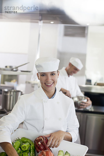 Chefkoch mit Gemüsebecher in der Restaurantküche