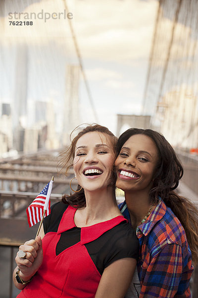 Lächelnde Frauen winken mit amerikanischer Flagge