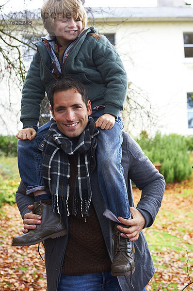 Vater trägt Sohn auf Schultern im Freien