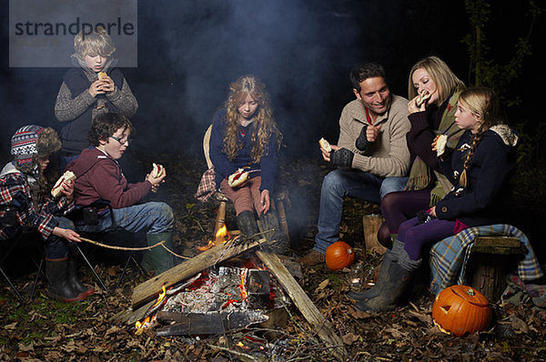 Familienessen am Lagerfeuer bei Nacht