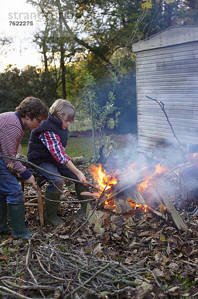 Jungen bauen Lagerfeuer im Freien