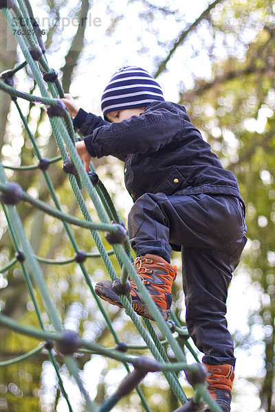 Kleinkind klettert auf einem Spielplatz