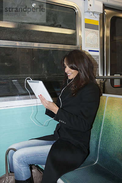 Frau mit Tablet-Computer in der U-Bahn