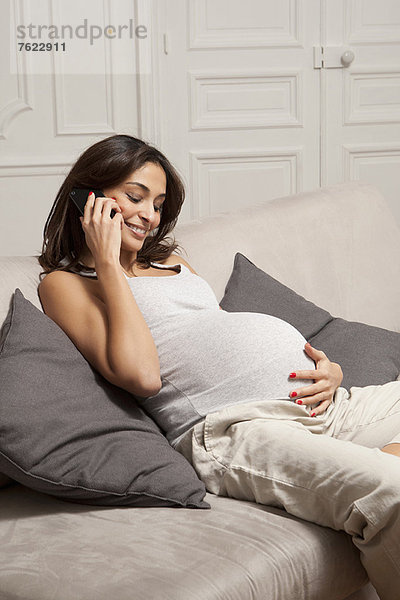 Schwangere Frau spricht am Handy