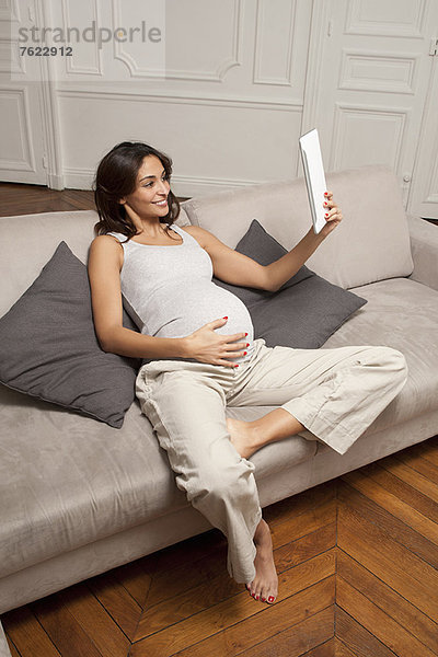 Schwangere Frau mit Tablet-Computer