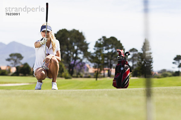 Frau spielt Golf auf dem Platz