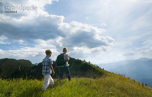 Vater und Sohn wandern auf grasbewachsenen Hügeln