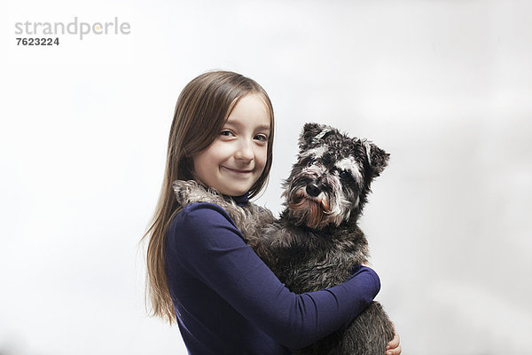 Lächelndes Mädchen hält Hund