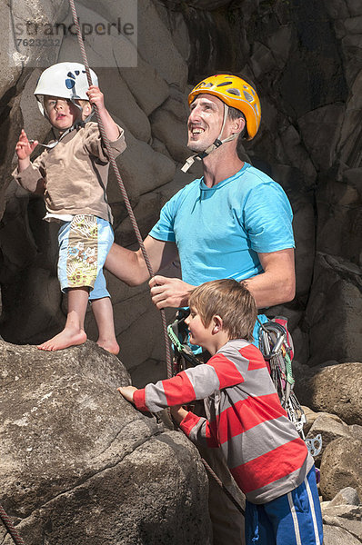 Mann  der Kindern das Klettern beibringt