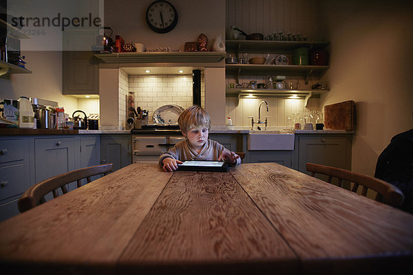 Junge mit Tablet-Computer am Tisch