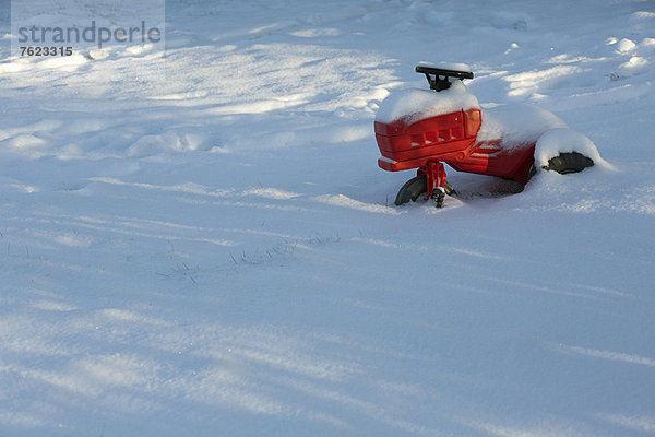 Kinderspielzeug im schneebedeckten Feld