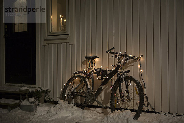 Fahrrad mit Lichterkette im Schnee