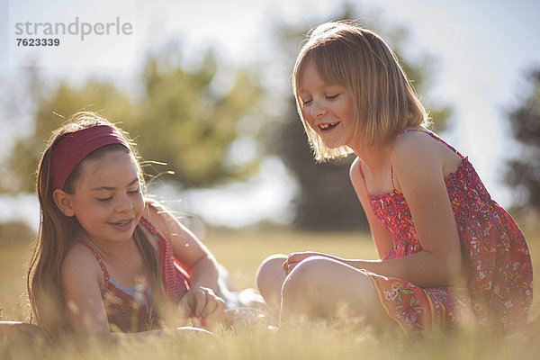 Lächelnde Mädchen spielen im Gras