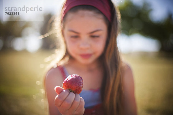 Mädchen essen Erdbeere im Freien
