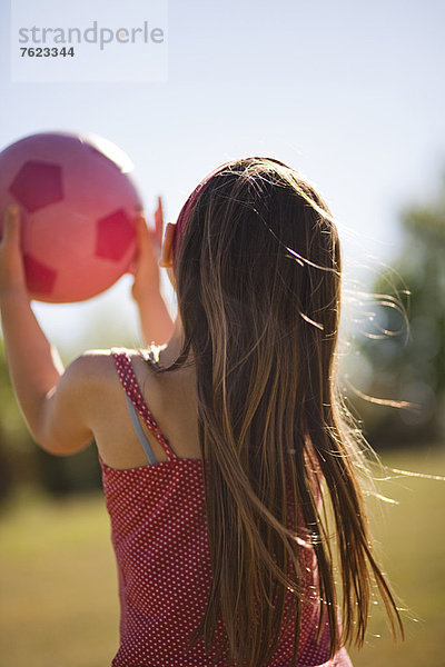 Mädchen mit Fußball im Feld