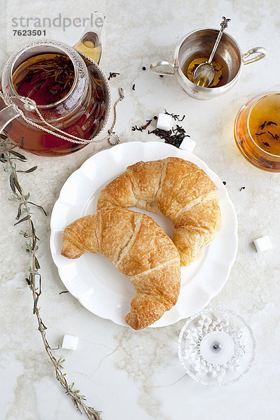 Croissants  Honig und Tee auf dem Tisch