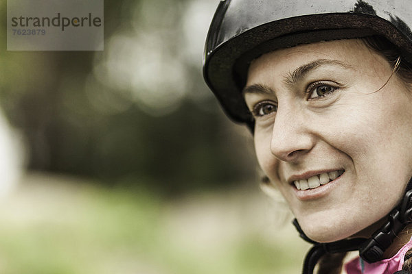 Lächelnde Frau mit Helm im Freien