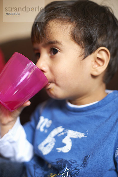 Junge trinkt aus Plastikbecher