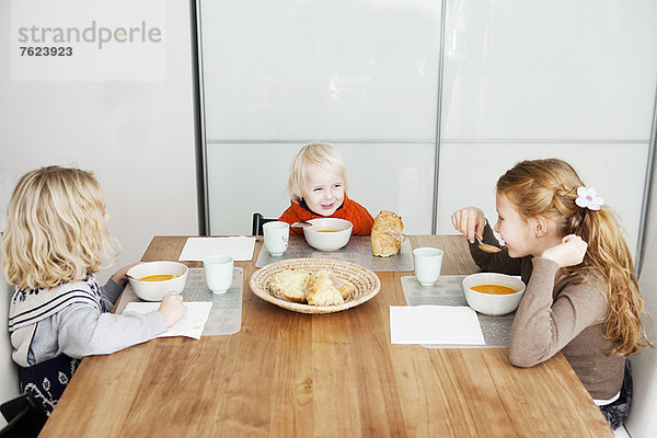 Kinder beim Mittagessen am Tisch