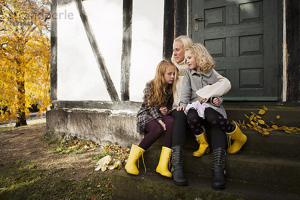 Mutter und Töchter im Freien sitzend