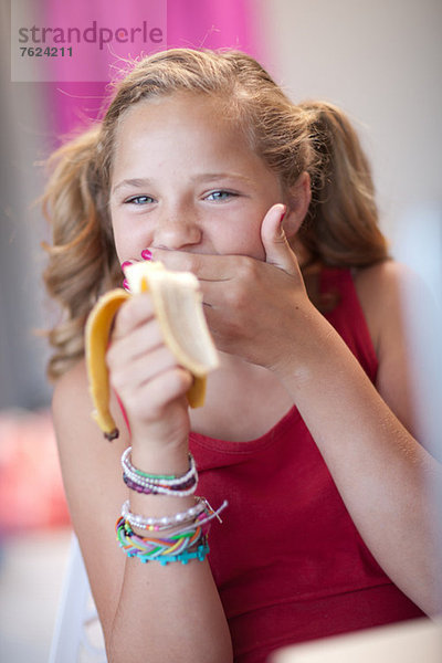 Lächelndes Mädchen beim Bananenessen