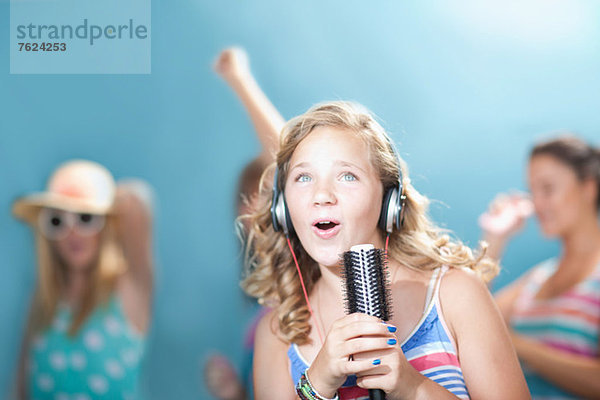 Mädchen singt in die Haarbürste