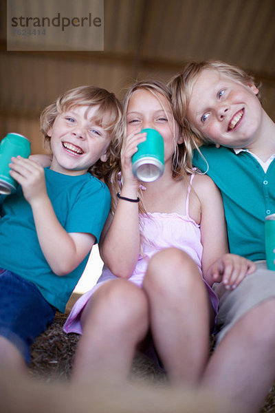 Kinder trinken Soda in der Garage