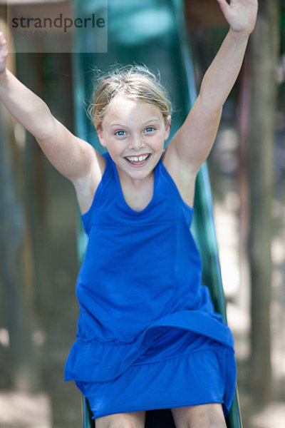 Mädchen beim Spielen auf der Rutsche im Freien