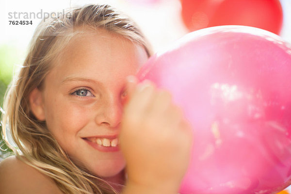 Lächelndes Mädchen mit Ballon auf der Party