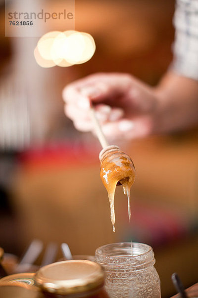 Frau untersucht Honig im Lebensmittelgeschäft