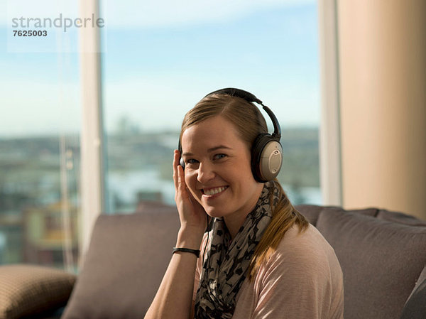 Lächelnde Frau beim Hören von Kopfhörern