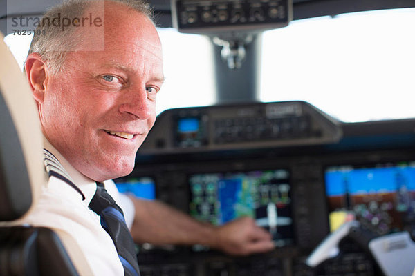 Pilot lächelt im Flugzeugcockpit