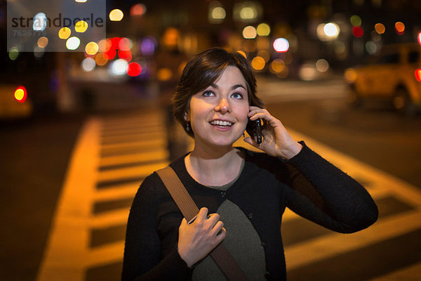 Frau auf dem Handy auf der Stadtstraße