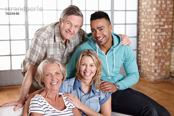 Familie entspannt gemeinsam auf dem Sofa