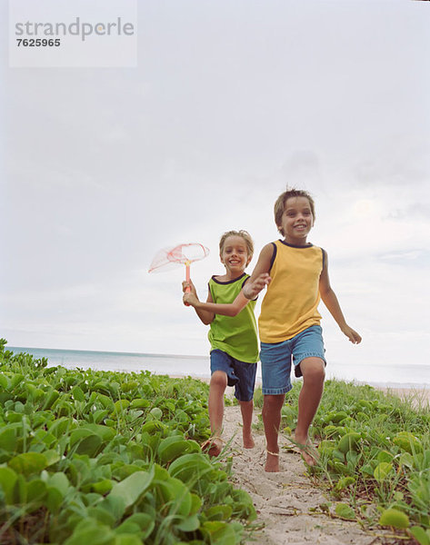 Kinder beim gemeinsamen Laufen am Strand