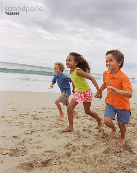 Kinder beim gemeinsamen Laufen am Strand