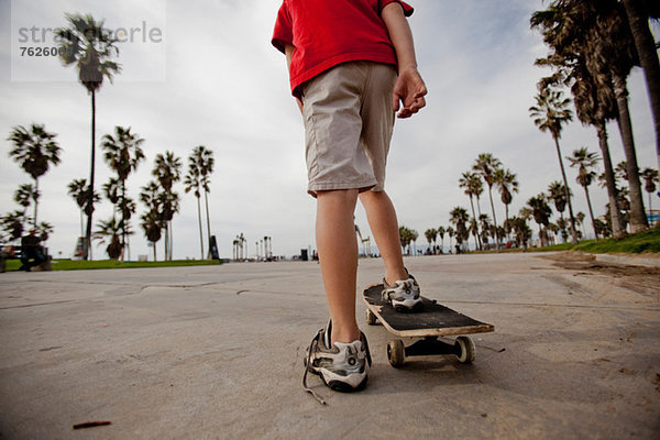 Junge reitet auf Skateboard im Park