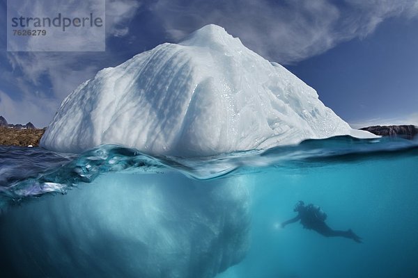 Eisberg unter Wasser mit Taucher davor  in der Nähe von Kulusuk  Grönland