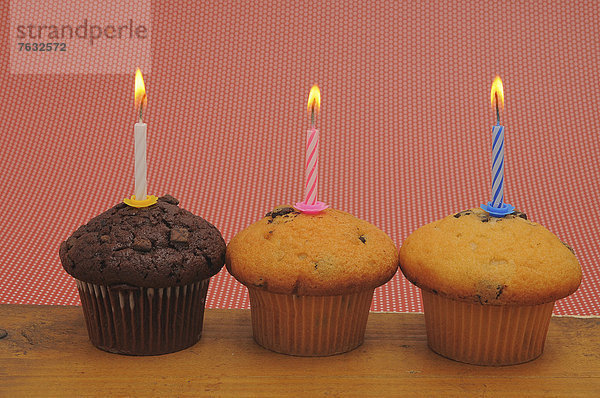 Drei Muffins mit Geburtstagskerzen