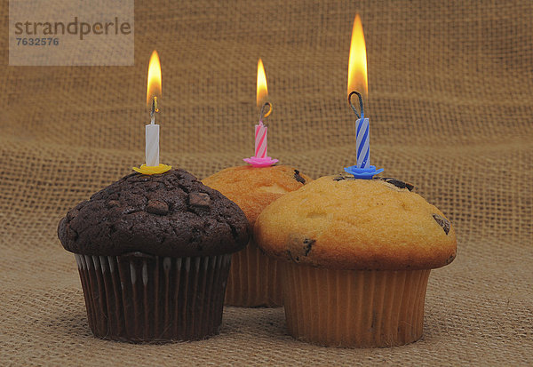 Drei Muffins mit Geburtstagskerzen