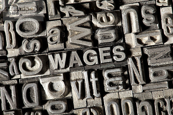 'Alte Bleilettern bilden das englische Wort ''WAGES'''