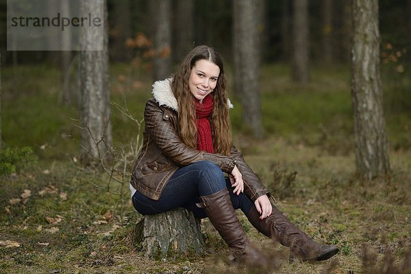 Lächelnde junge Frau im Wald