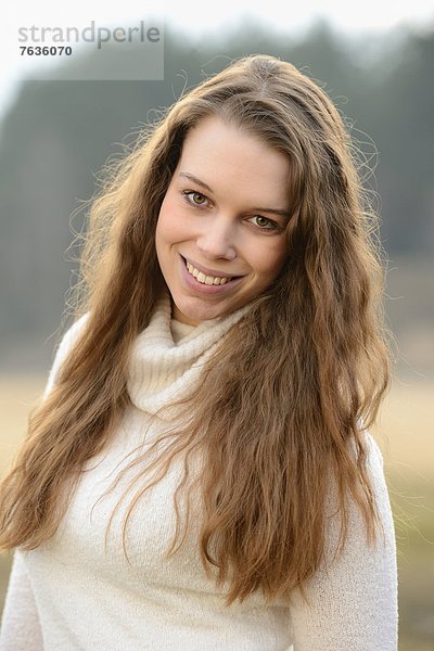 Lächelnde junge Frau im Freien  Porträt