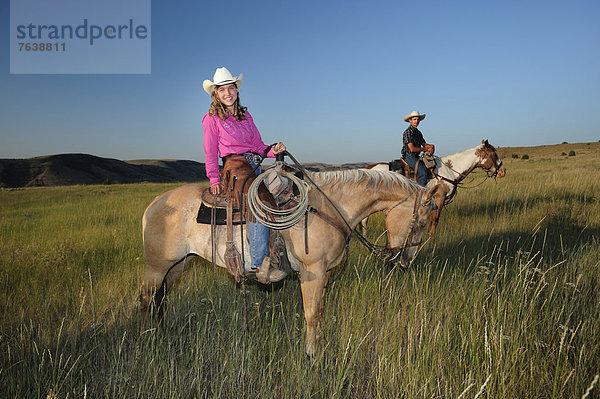 Vereinigte Staaten von Amerika  USA  Frau  Pose  Amerika  lächeln  fahren  reiten - Pferd  Gras  Mädchen  Cowboy  Cowgirl  Oregon  Prärie