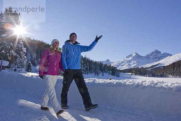 Frau Winter Mann gehen Weg wandern Kanton Graubünden Wanderweg Sonne trekking Wintersport