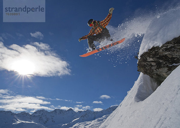 Berg Winter Mann Snowboard Snowboarding springen Kanton Graubünden Wintersport