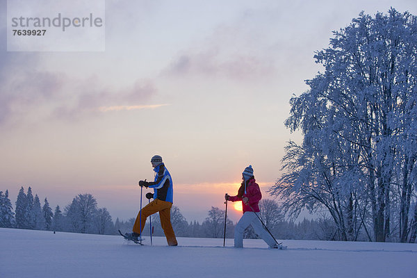 Schneeschuh Frau Winter Mann gehen Sonnenuntergang wandern Schnee Wintersport
